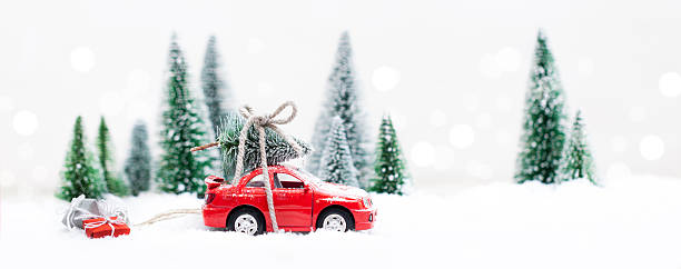 istock Winter Forest with miniature red car carrying a  christmas tree 615886454