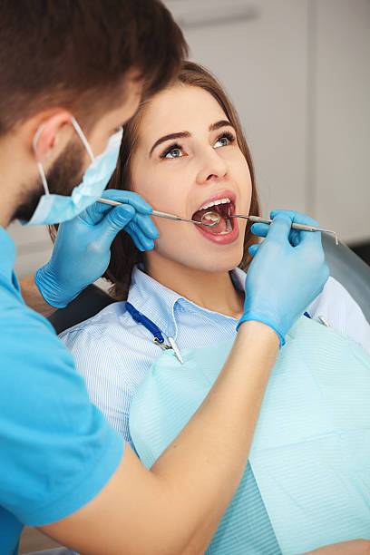 istock Young woman getting her teeth checked by a dentist. 615889336