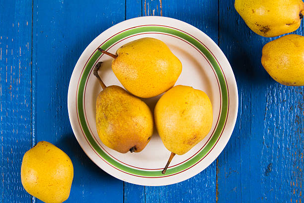 istock Fresh ripe organic yello pears on blue rustic wooden table 615890024