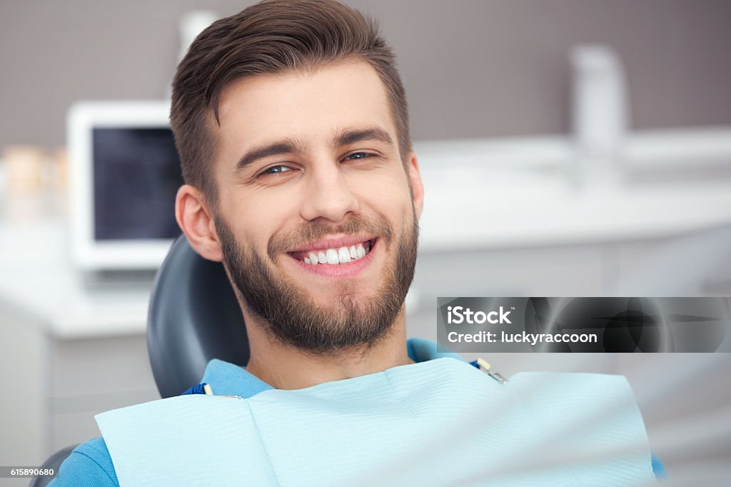 Porträt des glücklichen Patienten im Zahnarztstuhl. - Lizenzfrei Zahnarzt Stock-Foto