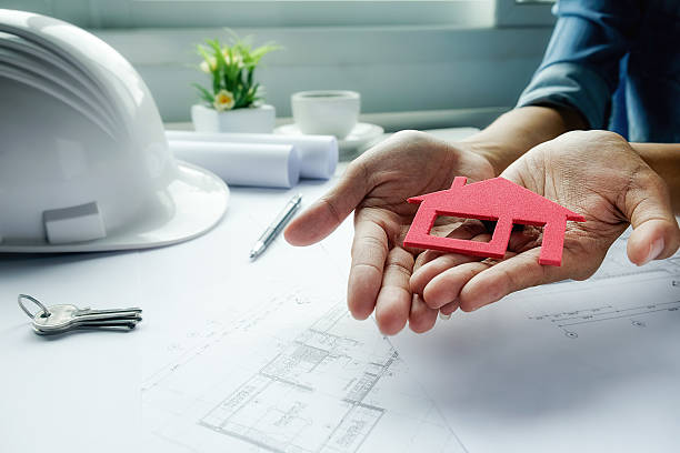 istock Female hand holds house model 615892792