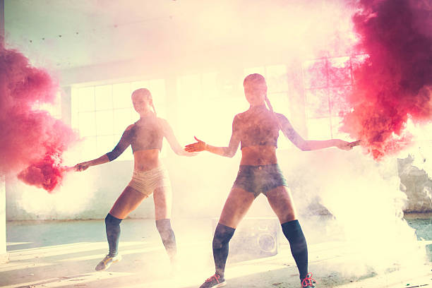 istock Two girls dancing in the smoke 615893556
