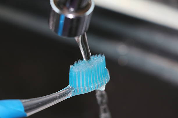 istock Toothbrush no more toothpaste near the tap sink open water 615896188