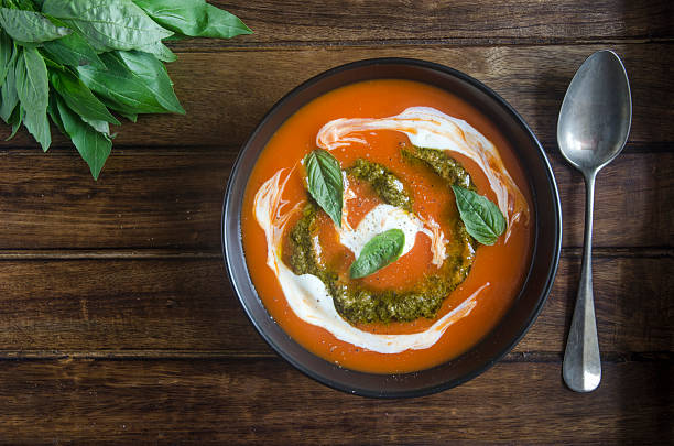 Tomato soup Tomato soup with pesto and soured cream tomato soup stock pictures, royalty-free photos & images