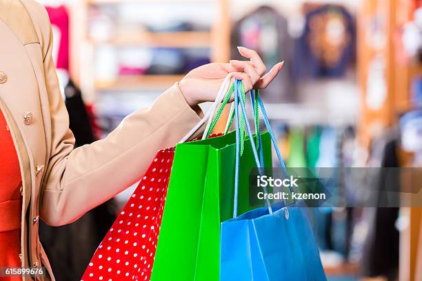 Woman With Shopping Bags In Shop Stock Photo - Download Image Now - Adult, Arts Culture and Entertainment, Bag