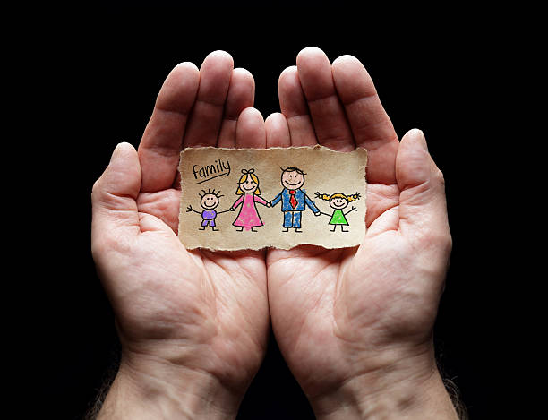 kind zeichnung der familie mit dem schutz der geschröpften hände - unity paper chain holding hands paper stock-fotos und bilder