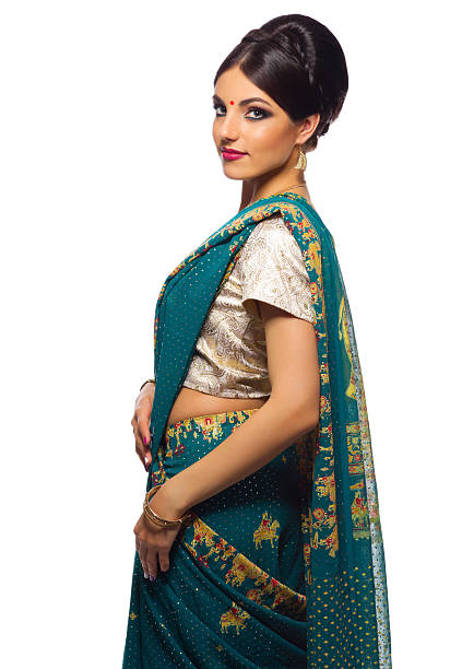 Portrait of teacher dressed in sari showing thumbs up while standing against white background