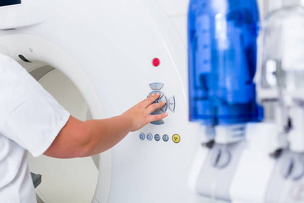 istock Nurse pressing button on CT machine in hospital 615902684