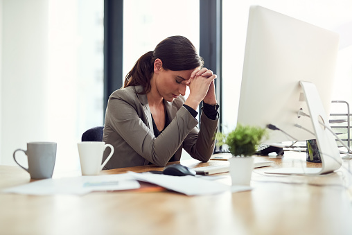 Cropped shot of a young businesswoman looking stressed out while working in an office