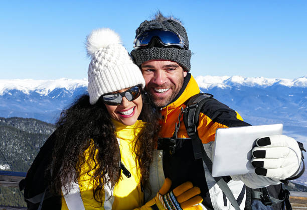 istock Couple embracing and making selfie on top snow mountain 615903176