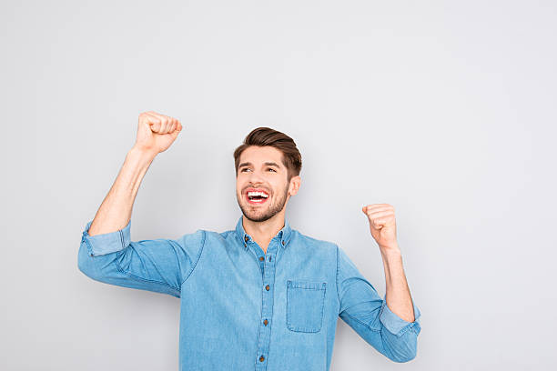 istock Portrait of glad man celebrating victory with raised hands 615904266