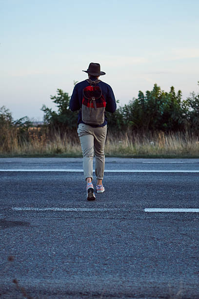istock Adventurous man strolling around the country road 615905144