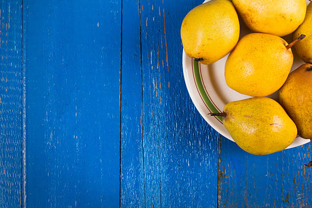 istock Fresh ripe organic yello pears on blue rustic wooden table 615905148
