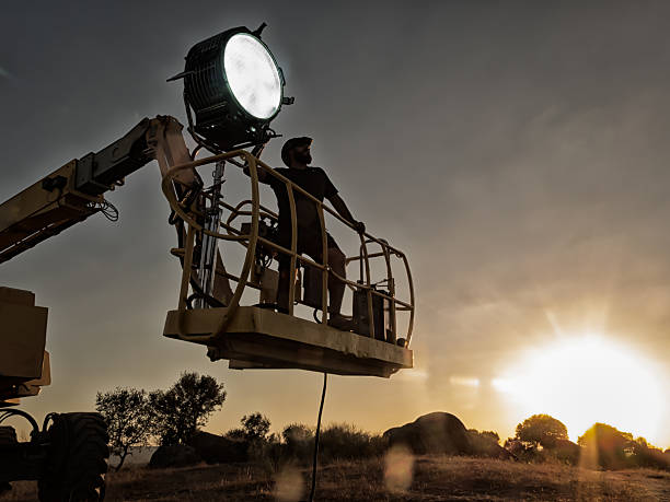 tecnico dell'illuminazione che lavora a una ripresa - studio cinematografico foto e immagini stock