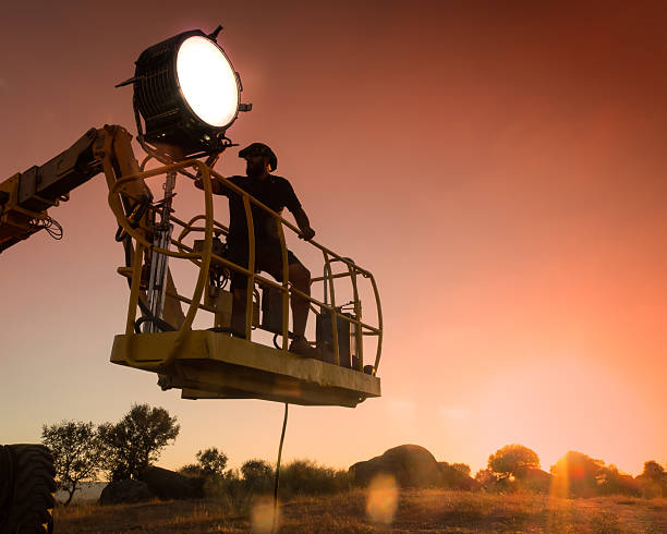 technicien d’éclairage travaillant sur un tournage - fresnel photos et images de collection