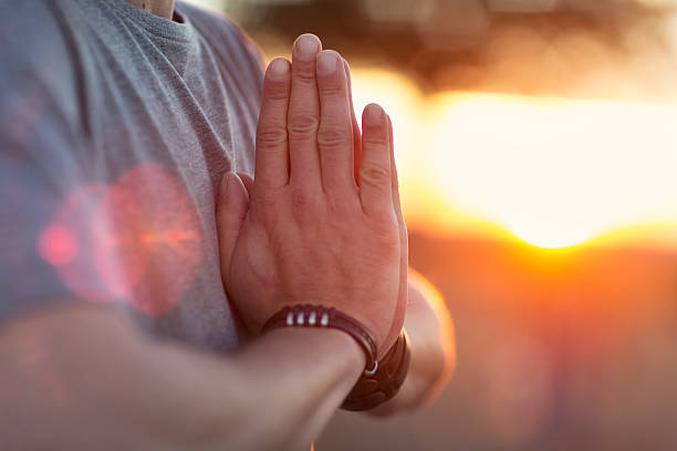 istock Hands of man praying at sunset 615909096
