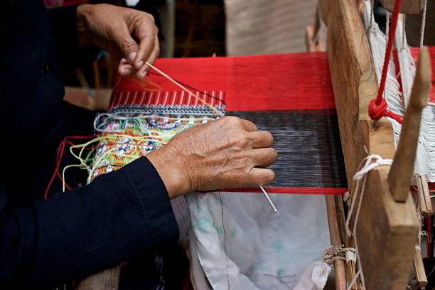 istock Old woman weaving on loom 615911044