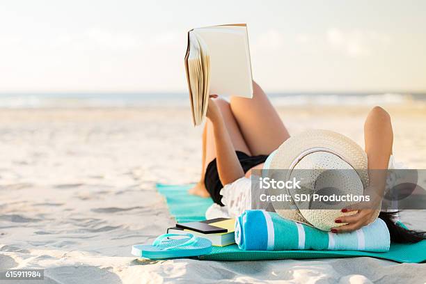 Woman Lies On The Beach Reading A Book Stock Photo - Download Image Now - Beach, Summer, Reading