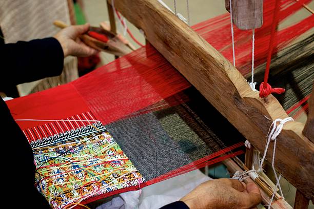 istock Old woman weaving on loom 615912158