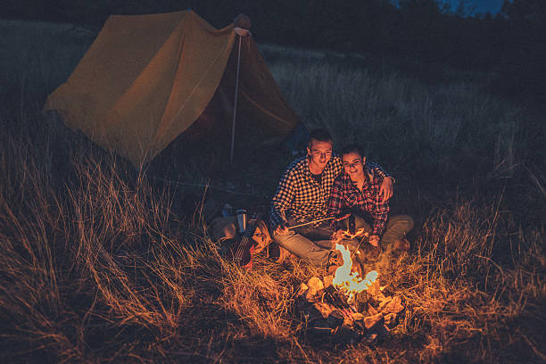 istock Couple preparing sausages on bonfire 615913142