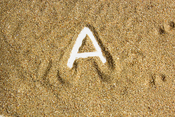 istock writing with  letter J made of  sand isolated  white inside 615913342