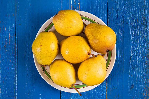 istock Fresh ripe organic yello pears on blue rustic wooden table 615913352