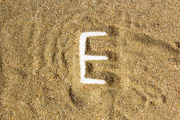 writing with  letter E made of  sand isolated  white inside