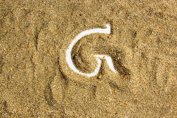 writing with  letter G made of  sand isolated  white inside