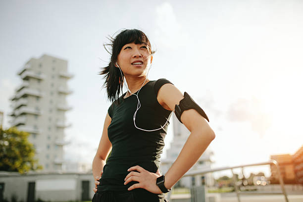 istock Asian female taking a break during morning run 615914702