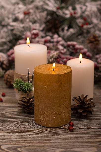 istock Fir branch in snow, lighted candle, cone on wooden background 615916012