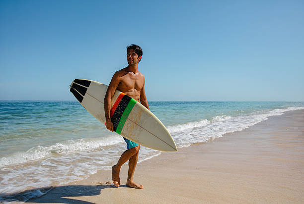 człowiek z surfowania pokładzie na plaży - surfing surf wave men zdjęcia i obrazy z banku zdjęć