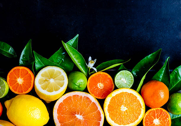 istock Assorted fresh citrus fruits with leaves. Background 615919548