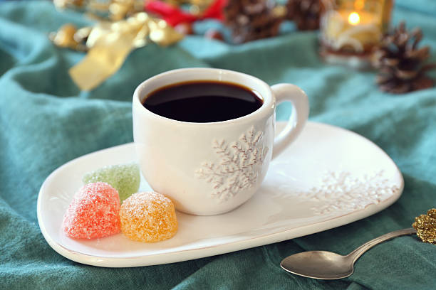 istock Cup of coffee, burning candle and colorful candy 615920390