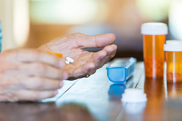 Senior male holding pills in his hand