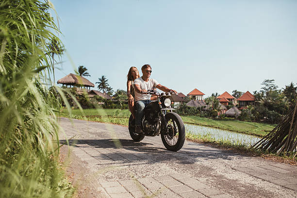 istock Young couple riding motorcycle on rural road 615924370