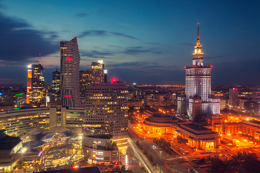 The skyline of central Warsaw (centrum) at night. On the right stands the Palace of Culture and Science, an example of stalinist architecture from the 1950s. On the left are office buildings and the Zlote Tarasy mall.