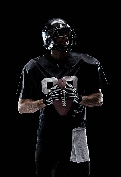 istock American football player holding ball 615928716