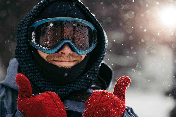 Thumbs up for winter holidays Portrait of cheerful young man enjoying the winter holiday thumbs up for skiing stock pictures, royalty-free photos & images