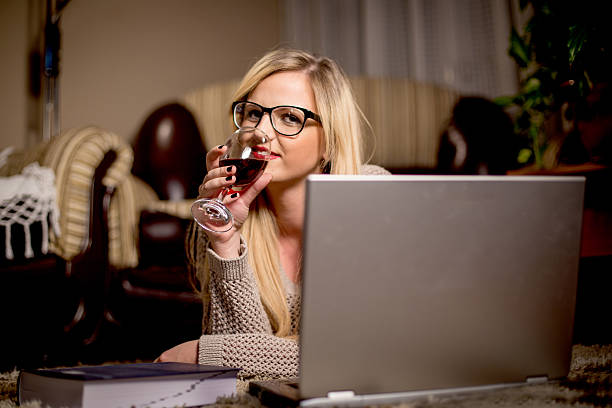 mulher com tablet de vinho tinto e laptop à noite - business styles foods and drinks drinking - fotografias e filmes do acervo