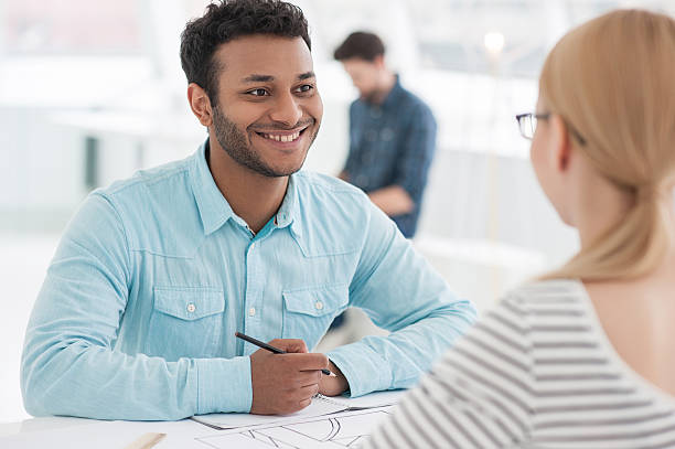 istock Two architects discussing details of blueprint 615980690