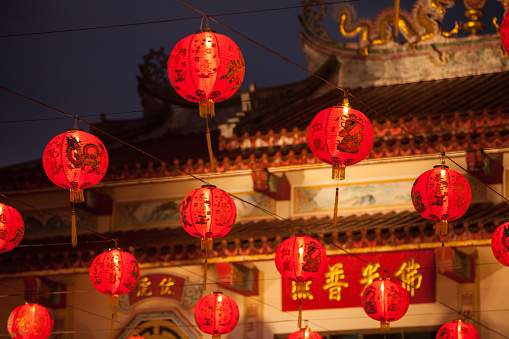 Red Chinese lantern in front of Chinese temple.