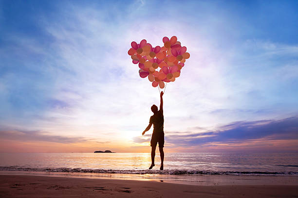 love concept love concept, man flying with heart from balloons, fall in love romance concept stock pictures, royalty-free photos & images