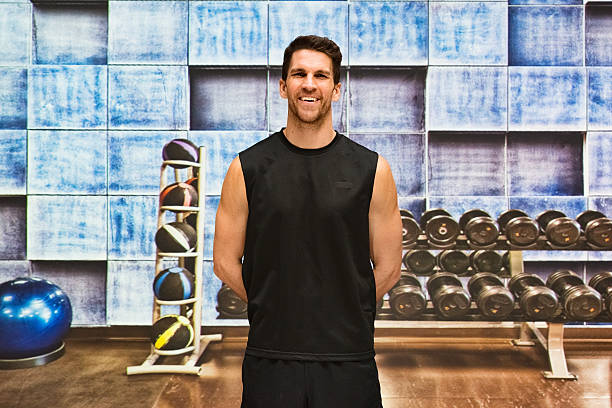 istock Smiling muscular man standing in gym 615989550