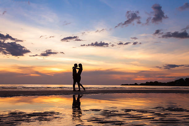 silhouette of couple on sunset beach