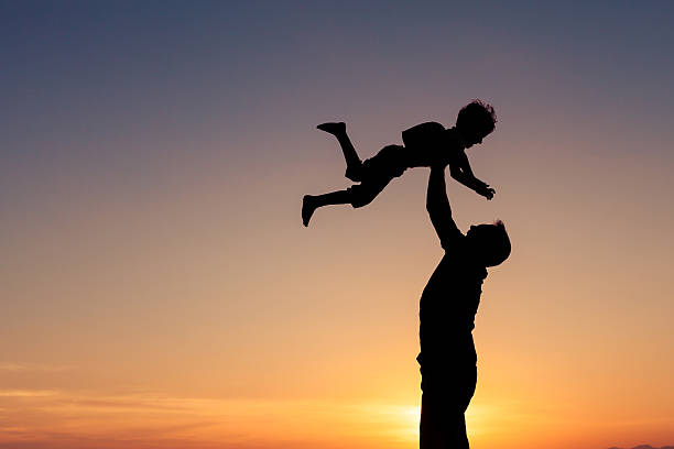 istock Father and son playing on the beach at the sunset. 615991596