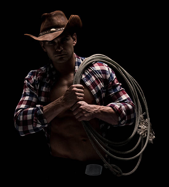 istock Muscular cowboy carrying lasso on his shoulder 615992406
