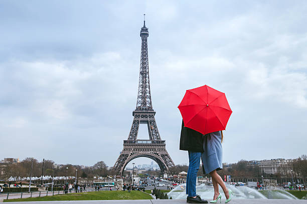 couple s’embrassant derrière un parapluie à paris - travel red vacations outdoors photos et images de collection