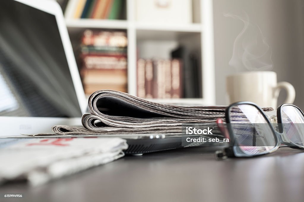 Büroarbeitsplatz mit Laptop und Brille auf dem Tisch - Lizenzfrei Zeitung Stock-Foto