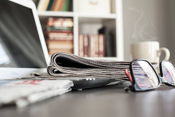 local de trabalho do escritório com laptop e óculos na mesa - newspaper reading broadsheet paper - fotografias e filmes do acervo