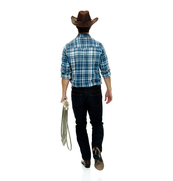 istock Rear view of cowboy walking 615996398